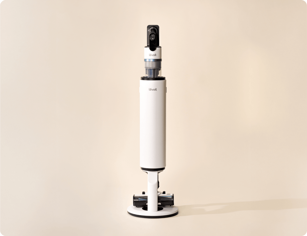 Levoit AERO™ cordless vacuum standing upright on its white docking station.
