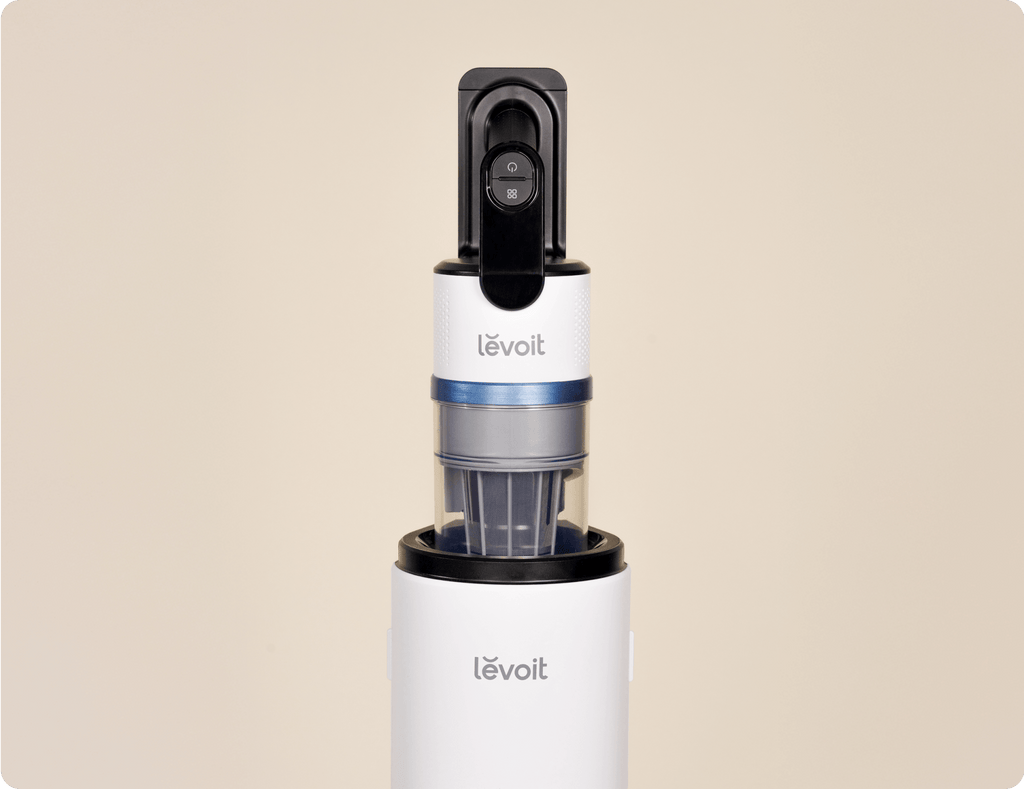 Close-up of Levoit AERO™ cordless vacuum handle and dustbin docked on the auto-empty station.