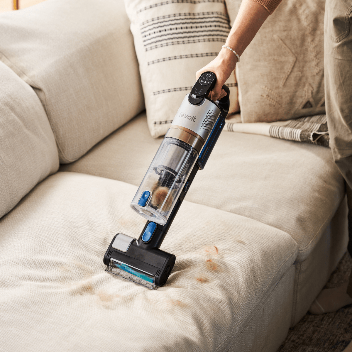 Levoit LVAC-300 handheld vacuum cleaner mode removing pet hair from sofa.